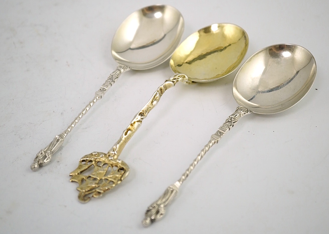 An early 17th century Dutch silver gilt spoon with galleon ship terminal, 18cm and two Victorian silver apostle spoons, Sheffield 1900, 17.5cm, 142g gross. Condition - fair